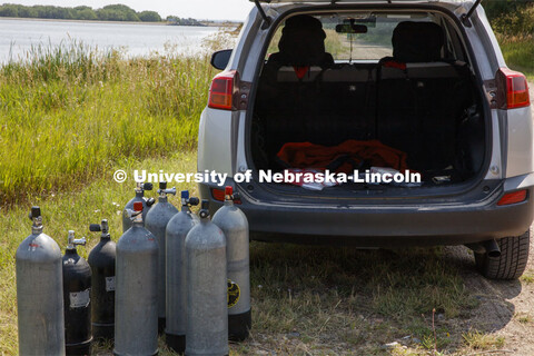 Students dive in Lake Ogallala under the watchful eye of Bill Belcher, assistant professor of anthro