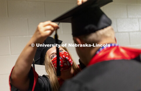 Lindsey LaBrie attaches Braden Wojahn’s tassel before the undergraduate commencement. Undergraduat