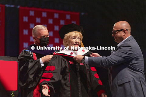 Leta Powell Drake, local television pioneer and Husker alumna, is hooded by NU Regent Tim Clare and 