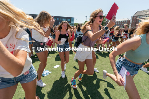 Students run to their chapter during Sorority Rush Bid on the Vine Street fields. Sorority bid day r