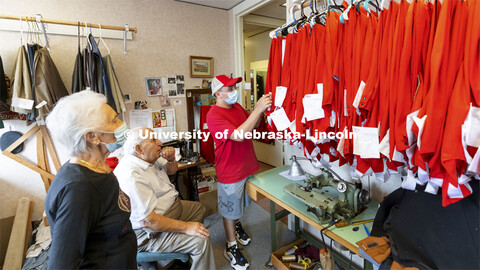 Demetrios Deligiannis and his wife Stamatia watch as Alfonso Meza picks up his altered uniform pants