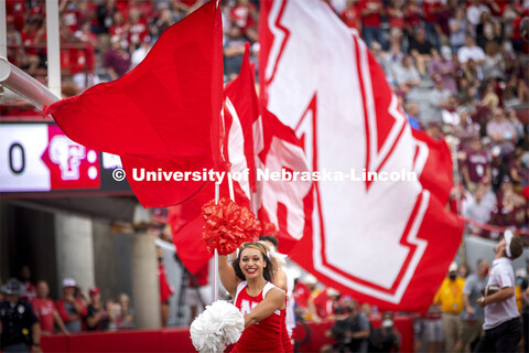 The Spirit Squad run across the field carrying the large Husker flags. Nebraska vs. Fordham Universi