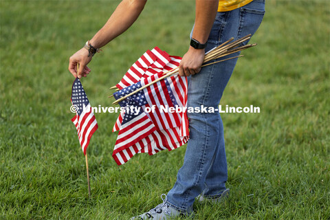 Students set out more than 100 flags in the green space north of the Nebraska Union to commemorate 9