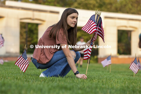 Madi Hadley, a freshman from Gunnison, Colorado, sets up flags in the green space north of the Nebra