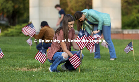 Madi Hadley, a freshman from Gunnison, Colorado, sets up flags in the green space north of the Nebra