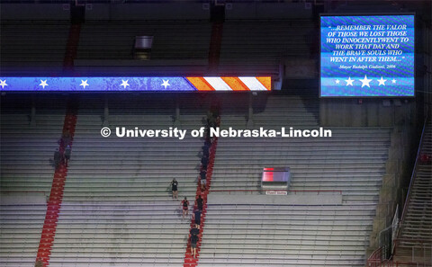 Navy and Marine ROTC members run up the east stadium steps. UNL ROTC cadets and Lincoln first respon