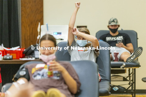 Caroline Carter, a junior from Omaha, holds her arm up following her donation. Homecoming week blood