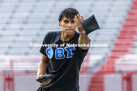 Sam Bates, a junior with the Phi Beta Sigma (National Pan-Hellenic Council) NPHC team, throws a bag 