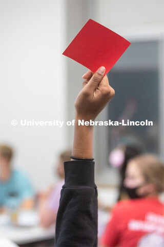 A student holds up a red card in an ALEC 102 class. Hannah Sunderman, Program Director, NHRI Leaders