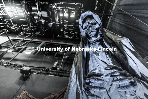 A dark skeleton / Grim Reaper guards the stage. The Nebraska Repertory Theatre has turned Howell The