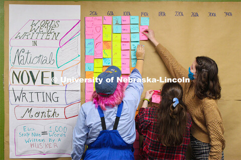 NaNoWriMo students — (from left) Wren Shawhan, Annie Lammes and Victoria Diersen — place sticky 