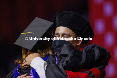 Tyler Kozisek hugs his advising professor Angela Pannier after he was hooded at the Graduate Commenc