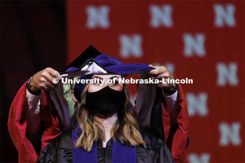 Lindsay Bartholomew receives her Juris Doctor hood. Graduate Commencement at Pinnacle Bank Arena. De