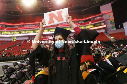 Peyton Millard shows off her new masters diploma to her friends and family in the arena. Graduate Co