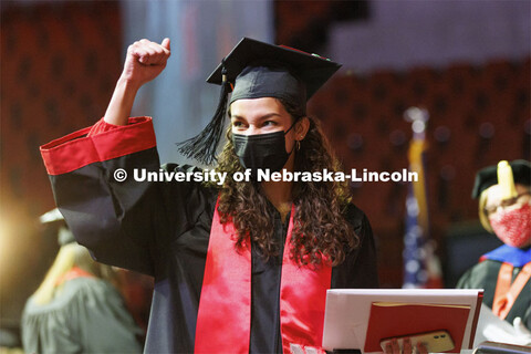 Maya Bullock gestures to her family and friends in the arena after receiving her CEHS diploma.  Unde