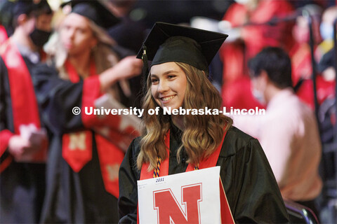 Mary Miners smiles as she is photographed after walking off stage with her CoJMC degree. Undergradua