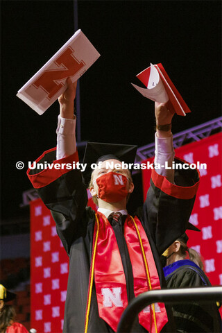 Arts and Sciences graduate Tyler Banark celebrates as he walks off the stage at the Undergraduate Co