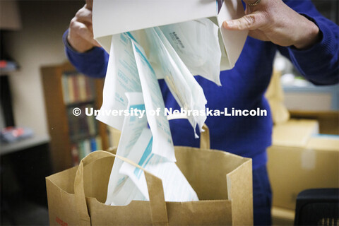 Jon Gayer, Assistant Director of Fraternity and Sorority Life, sorts masks into bags for distributio
