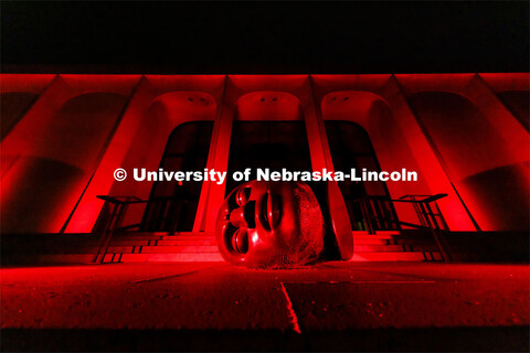 The Sheldon Memorial Art Gallery and Fallen Dreamer sculpture are bathed in red lights for Glow Big 