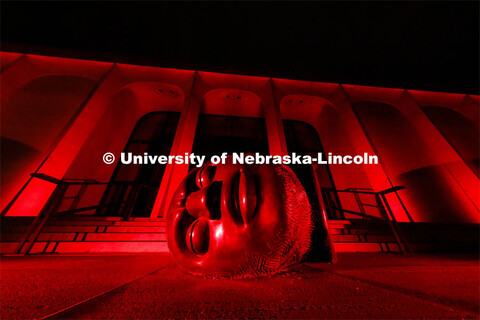The Sheldon Memorial Art Gallery and Fallen Dreamer sculpture are bathed in red lights for Glow Big 