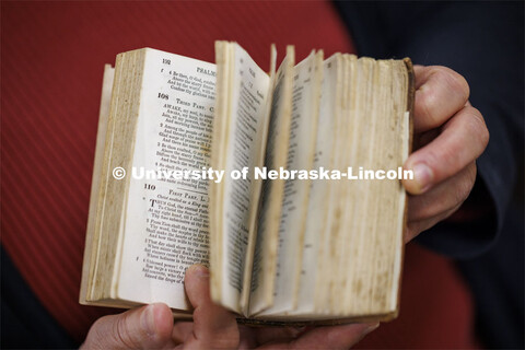 Anita Breckbill, professor, holds one of the smallest books in the collection: Manual of Christian P