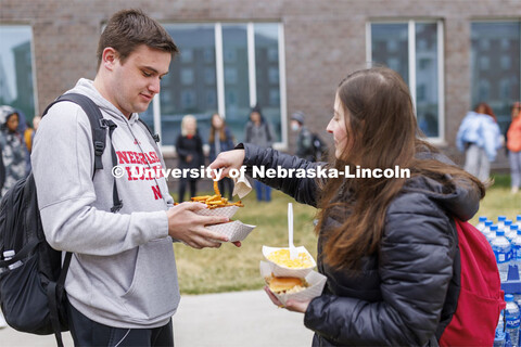 Jolie Peal grabs a fry from Brandon Mueting’s Motorfood lunch. Students lined up for Food Trucks @