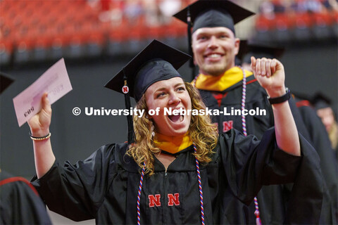 Courtney Brummel gestures to family and friends as she enters the arena. Graduate commencement in Pi