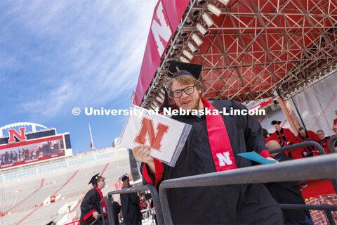 CoJMC graduate Jordan Opp shows off his diploma. UNL undergraduate commencement in Memorial Stadium.