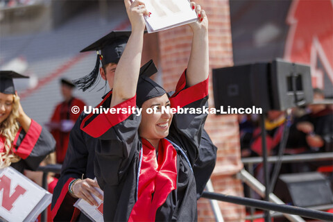 Mia Spedale shows off her UNL diploma to friends and family. UNL undergraduate commencement in Memor