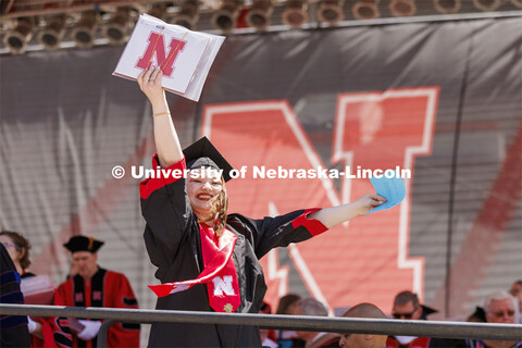 Katelynn Meadows waves to her family as receiving her diploma. UNL undergraduate commencement in Mem