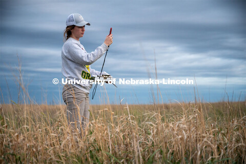 PhD student Grace Schuster uses a Kestrel to measure wind speed during point counts, which are used 