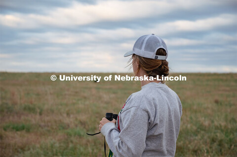 PhD student Grace Schuster looks and listens for different bird species during point counts, which a