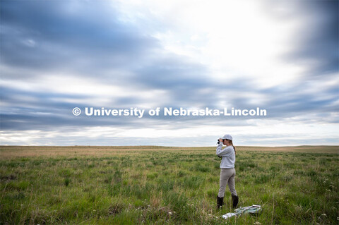 PhD student Grace Schuster looks and listens for different bird species during point counts, which a