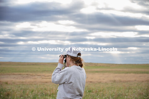 PhD student Grace Schuster looks and listens for different bird species during point counts, which a