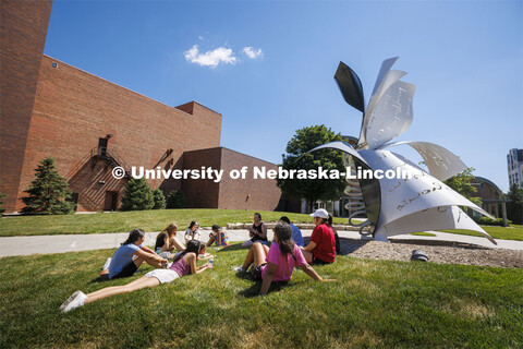 Summer camp students sit on the lawn by the Torn Notebook sculpture. July 12, 2022. 