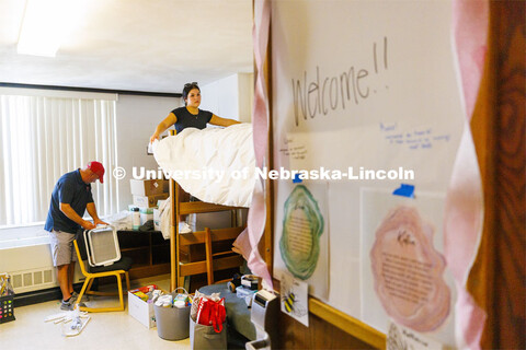 Keah Krings of Hastings makes her bed with her family’s help while her dad works on assembling a r