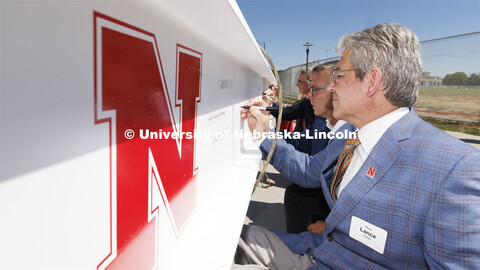 College of Engineering Dean Lance Perez signs his name to the final beam along with Chancellor Ronni