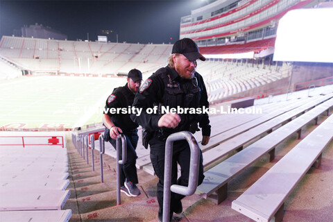 UNLPD Officer Michael Dailey, right, and UNLPD Investigator Caleb Gose walk the north stadium steps.