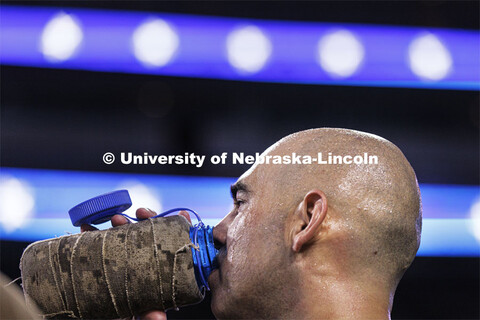 Sweat glistening on his head, Marine Gunnery Sargeant Josh Glotzbecker grabs a drink after making th