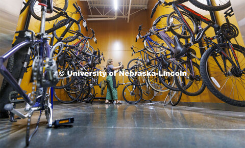 Katie Furlong, a senior from Dallas, adds a bike to the finished side of the repair area. Outdoor Ad