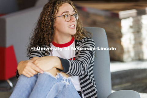 One student sitting in a commons area. Housing Photo Shoot in Able Sandoz Residence Hall. September 