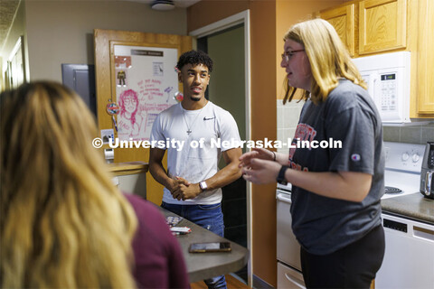 Students socializing in an apartment style room in The Courtyards Residence Hall. Housing Photo Shoo