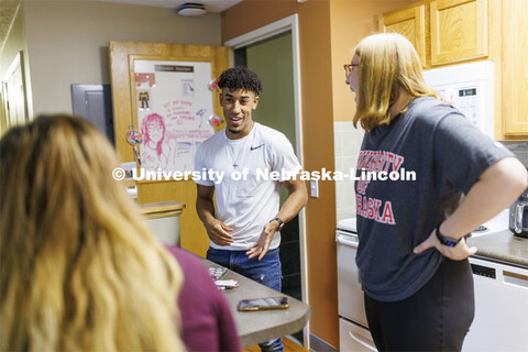 Students socializing in an apartment style room in The Courtyards Residence Hall. Housing Photo Shoo