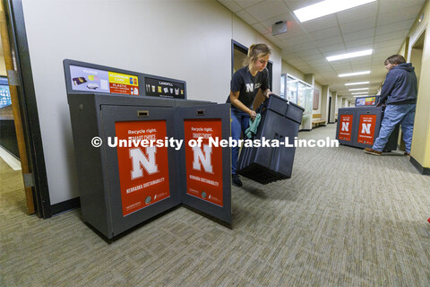 Sustainability Program Assistant Anna Oetting wipes down the new recycling stations in Gwendolyn A. 