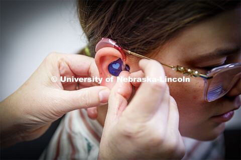 Audiologist Stacie Ray checks the ears and hearing aids of 13-year-old Chloie Lechance in the Barkle