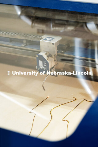 The laser cutter completing the student’s design. Architecture design professor Aziza Cyamani is d