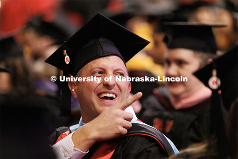 Zachariah High gestures to his family and friends. Graduate Commencement in Pinnacle Bank Arena. Dec