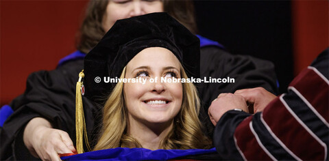 Haley Beer smiles as she receives her hood. Graduate Commencement in Pinnacle Bank Arena. December 1