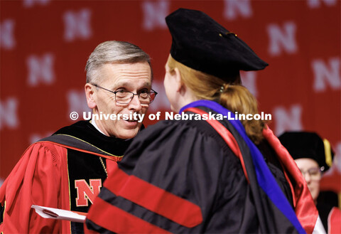 Chancellor Ronnie Green talks with each doctoral and masters graduate after he hands them their dipl