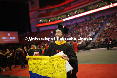 Juan David Jimenez Pardo waves the Colombian flag he carried through commencement. Pardo received hi